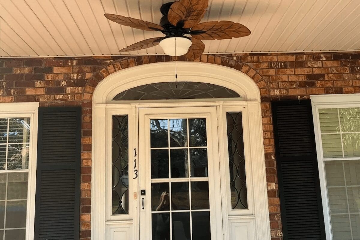 A front door with a fan and light on it